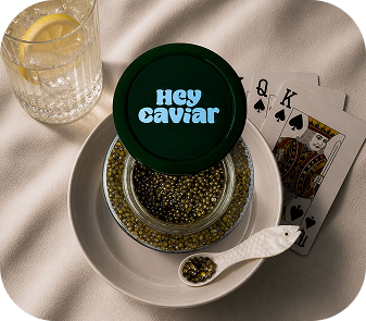Hey Caviar jar beside a drink for the Where Should You Buy Caviar Online guide